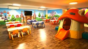 a kindergarten classroom with a play area with tables and chairs at 妖怪森林 The M Village in Lugu