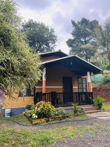 a small yellow house with a porch at Wayanad Cocos Villa in Tariyod