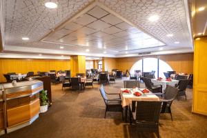 uma sala de jantar com mesas e cadeiras num restaurante em Hamdan Plaza Hotel Salalah, an HTG Hotel em Salalah