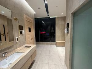 Axon Residence By Leo Suites في كوالالمبور: حمام كبير مع حوض ومغسلة