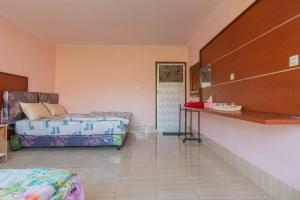 a room with two beds and a counter in it at Villa Strawberry Sembalun in Sembalunbumbung