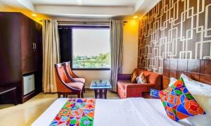 Habitación de hotel con cama, silla y ventana en FabHotel SP Plaza Greater Kailash, en Nueva Delhi