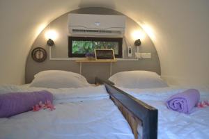 a bedroom with two beds and a tv on the wall at Bagan Pinang Guest House in Port Dickson