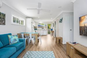 un salon avec un canapé bleu et une table dans l'établissement Tea Gardens Cosy Cottage, à Tea Gardens 12 autres photos