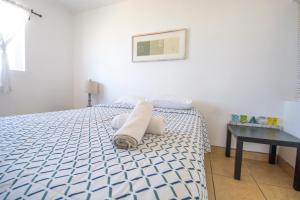 a bedroom with a bed with a blue and white bedspread at Beachfront, sun, sand & fun - Cozy 1 Bdr Apt in Tijuana