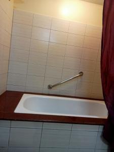 a bath tub in a bathroom with a rod on the wall at Apo 201-Alta Vista De Boracay in Boracay