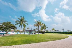 um parque com palmeiras e um parque infantil em Hamdan Plaza Hotel Salalah, an HTG Hotel em Salalah