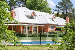 ein Haus mit einem Zaun davor in der Unterkunft Iona Park, Moss Vale in Moss Vale