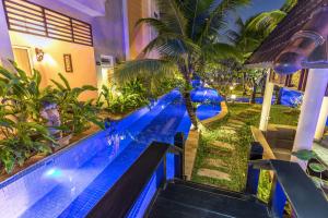 a swimming pool in a resort with a palm tree at Bali Hotel in Phnom Penh