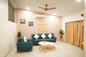 sala de estar con sofá azul y mesa en Visava Amusement Park & Resort Navi Mumbai en Navi Mumbai