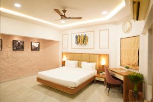 a bedroom with a bed and a desk and a bed and a table at Visava Amusement Park & Resort Navi Mumbai in Navi Mumbai