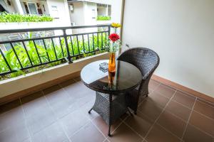 a table with a vase of flowers on a balcony at Bali Hotel in Phnom Penh