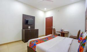 Schlafzimmer mit einem Bett und einem Flachbild-TV in der Unterkunft FabHotel Grand Model Town Inn in Jalandhar