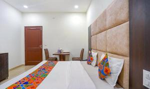 ein Schlafzimmer mit einem großen Bett in einem Zimmer in der Unterkunft FabHotel Grand Model Town Inn in Jalandhar