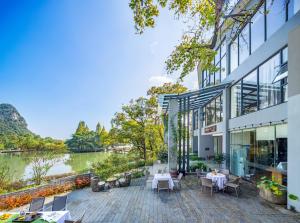 an exterior view of a building with a lake at Guilin HeShe Lakeside Resort in Guilin