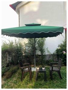 two chairs and a table under an umbrella at 2 Bedroom Pine View Cottage with Lawn in Nainital