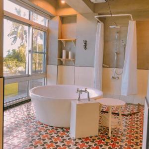 Noosa海岸行館 في فينغبين: حمام كبير مع حوض استحمام ودش