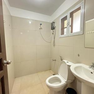 a bathroom with a toilet and a sink at Earl De Princesa Hotel in Puerto Princesa City