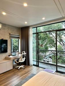 - une chambre avec un lit, un bureau et une fenêtre dans l'établissement Khánh Nguyễn Luxury Apartment, balcony street view, large bathtub, à Hô-Chi-Minh-Ville