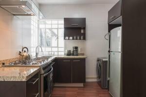 a kitchen with a stove and a refrigerator at Condesa Residence Amsterdam E Cozy Living Space in the Heart of the City on Amsterdam Avenue in Mexico City +22 photos