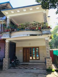 ein Haus mit Topfpflanzen darüber in der Unterkunft Rajas Basera Homestay in Alappuzha