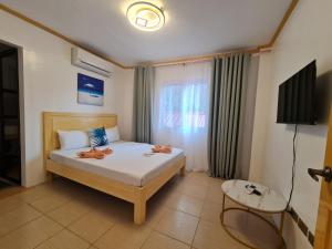 1 dormitorio con 1 cama y TV en Hotel Pressie by SMS Hospitality en Panglao