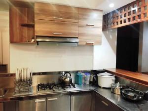a kitchen with stainless steel appliances and wooden cabinets at Bagasbas House in Daet