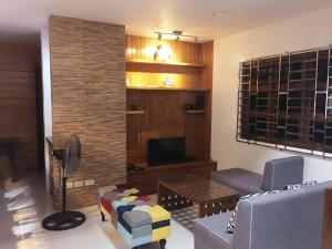 uma sala de estar com um sofá e uma televisão em Bagasbas House em Daet