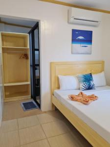 Un dormitorio con una cama con una toalla. en Hotel Pressie by SMS Hospitality en Panglao