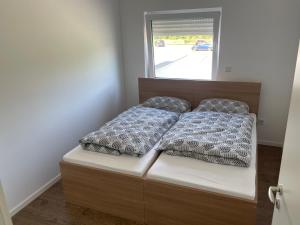 ein Bett mit zwei Kissen und einem Fenster in der Unterkunft Penthouse Ob2 in Bad Essen