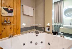 a large white bath tub in a bathroom at Cupid Hotel in Ho Chi Minh City