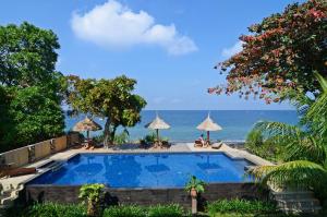 una piscina con el océano en el fondo en Sunsethouse Lombok, en Senggigi 