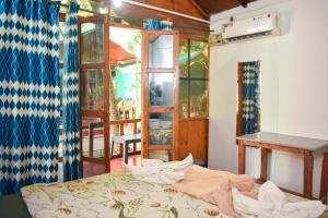 a room with a bed and a table and a window at Home De francisco in Canacona