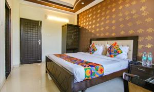 a bedroom with a large bed in a room at FabHotel CP Palace Race Course in Dehradun