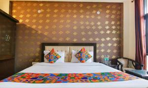 a bedroom with a large bed with a colorful comforter at FabHotel CP Palace Race Course in Dehradun