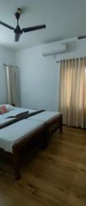 a bedroom with a bed and a ceiling fan at Tess Holistay Fort Kochi in Fort Kochi