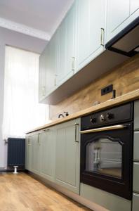 a kitchen with white cabinets and an oven at Grey Symphony in Timişoara
