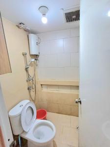 uma pequena casa de banho com WC e chuveiro em Bassura City Apartment by Sang Living em Jakarta