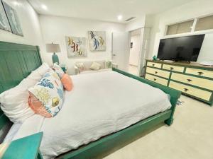 um quarto com uma cama grande e uma cómoda com uma televisão em 2 Bedroom At The Marbella Towers Beachfront num1705 em Juan Pedro