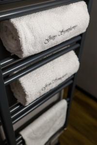 a towel rack with white towels on it at Grey Symphony in Timişoara