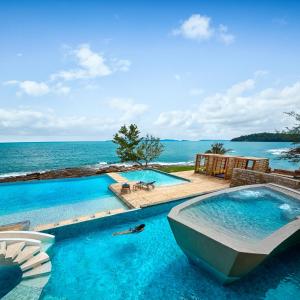 a swimming pool with a view of the ocean at Pod Village by Independence Hotels in Sihanoukville