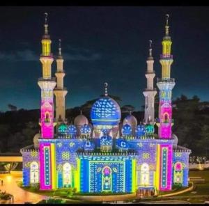 une mosquée éclairée en rose et en bleu dans l'établissement Apartement Podomoro golf view exit toll cimanggis, à Bogor