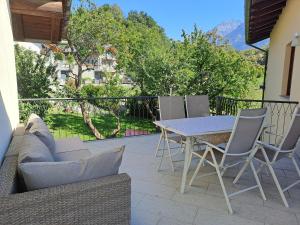 a patio with a couch and a table and chairs at Aosta Stunning Panoramic Views From Modern Two Bedroom Apartment in Aosta
