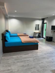 1 dormitorio con 1 cama grande con sábanas azules en CK Residence, en Songkhla