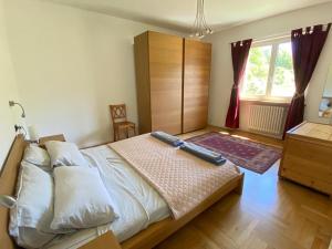 a bedroom with a large bed and a dresser at Aosta Stunning Panoramic Views From Modern Two Bedroom Apartment in Aosta
