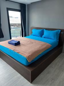 1 cama grande con sábanas azules y almohadas azules en CK Residence, en Songkhla