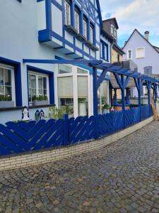une clôture bleue devant une maison dans l'établissement Ferienwohnungen Am Markt, à Rüdesheim am Rhein