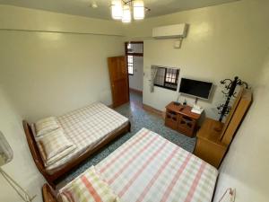 鹿谷的住宿－溪頭雅園民宿	 ，小房间设有两张床和电视