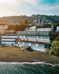 un grande edificio bianco sulla riva di un corpo idrico di Fevzi Hoca Butik Hotel a Trabzon