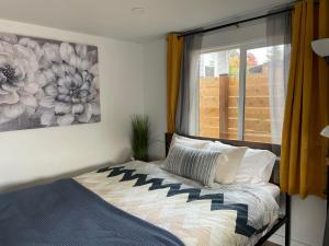 1 dormitorio con 1 cama con una pintura en la pared en NEW private tiny home near GreenLake/Lightrail/I-5 en Seattle